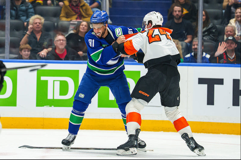 Hockey players in action on the ice with a crowd watching.