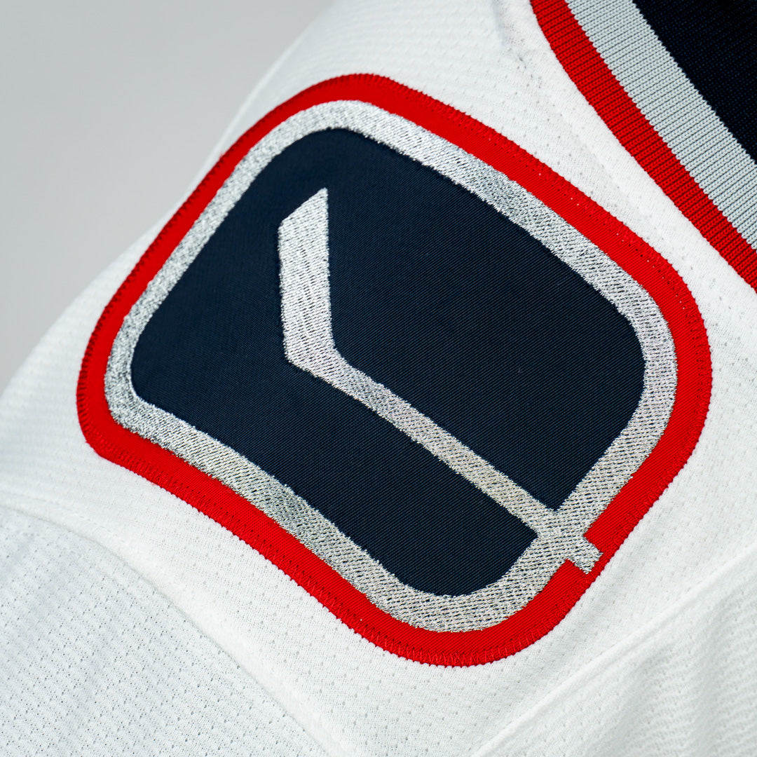 Close-up of a sports jersey with a logo featuring a hockey stick and puck.