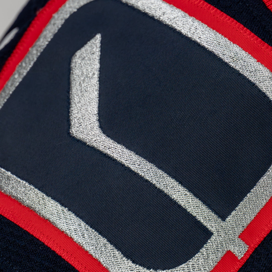 Close-up of a sports jersey with a logo on a navy background