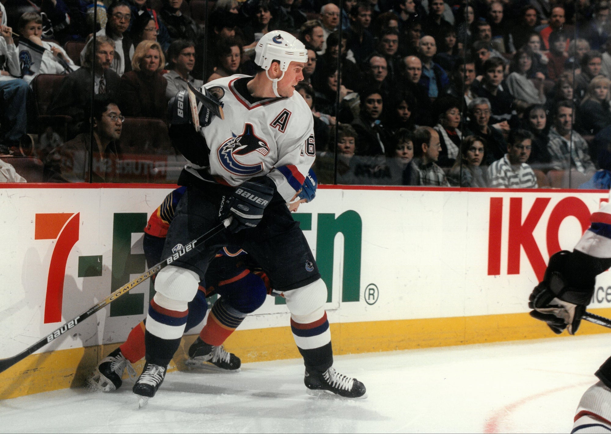 Hockey player in action on the ice with spectators in the background