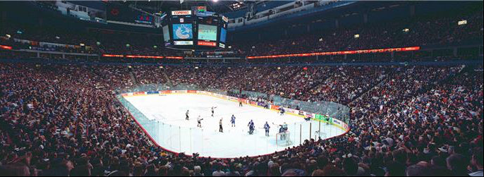 Hockey game in an indoor arena with a large crowd.